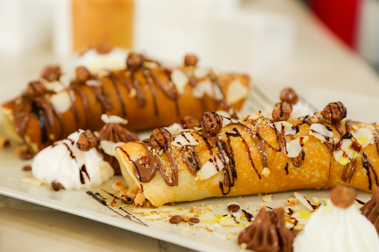Crepes alla Nutella perfette, sottili e dorate su un piatto, pronte da gustare.