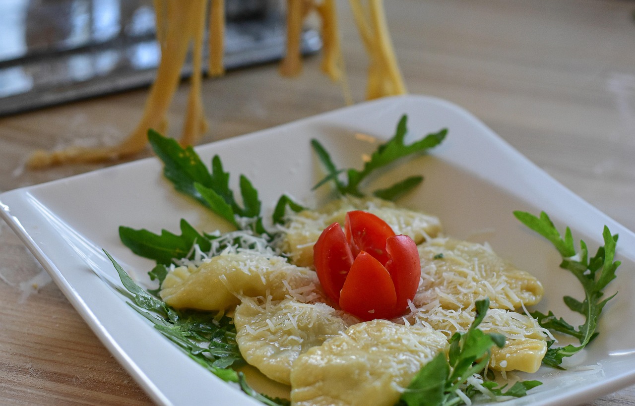 Ravioli freschi ripieni di ricotta e spinaci su un piano di lavoro con farina.