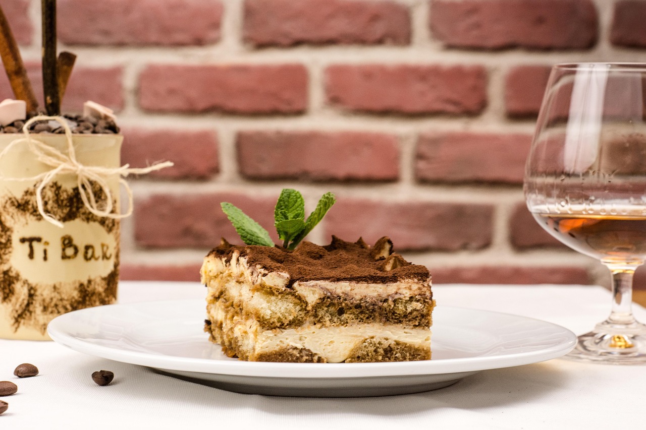 Fetta di tiramisù originale con cacao in polvere e decorazione al cioccolato.