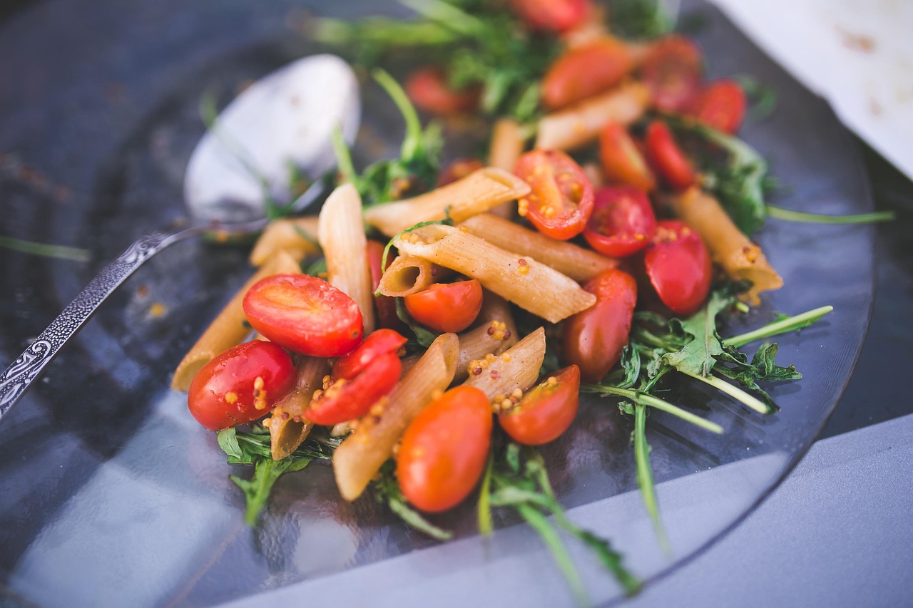 Piatto di pasta al pomodoro con ingredienti freschi su un tavolo, evidenziando errori di preparazione.