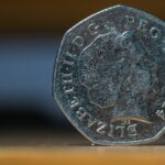 Moneta da 50 centesimi rara, valutata fino a 12.800€, esposta su sfondo neutro.